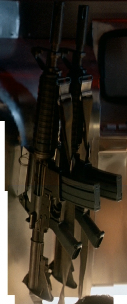 The pair of carbines hanging on the wall. Note: This image is made up from several stills, as the camera moves from the muzzle downwards in close-up and additionally zooms out a bit during the motion.